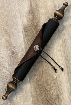 an old style black and brown umbrella laying on top of a wooden floor