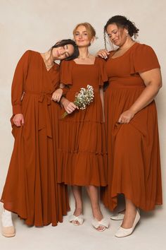 three women in brown dresses standing next to each other