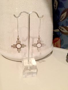 "Beautiful zia sun dangle earrings, a simple but elegant look for any outfit! The antique silver toned brass ear wires measure 1 3/10\" x 9/10\", and the zia sun charms measure 1 1/8\" x 1\" (Total length is approximately 2.5\") All items are lead and nickel free, message with any questions, thanks!" Silver Brass Earrings With Sun Design, Silver Sun Design Brass Earrings, Zia Symbol, Sun Jewelry, Symbol Jewelry, Sun Earrings, Tyler Tx, Symbolic Jewelry, Ear Wires