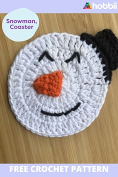 a crocheted snowman hat with an orange nose and black hair on it