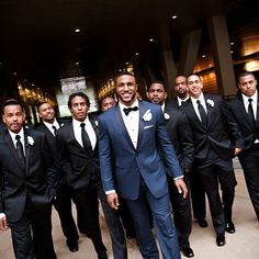 a group of men in tuxedos standing next to each other wearing suits and ties