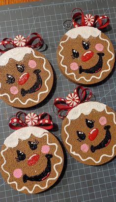 four gingerbread cookies decorated with bows and glitters on top of a cutting board