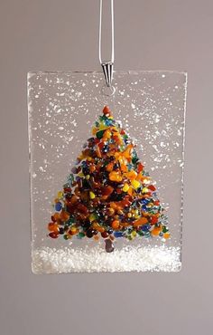 a glass ornament with a christmas tree made out of gummy bears in it