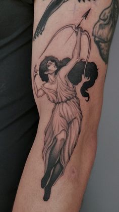 a woman with a bow and arrow tattoo on her arm