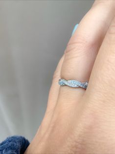 a woman's hand with a wedding band on it, and the ring is in white gold