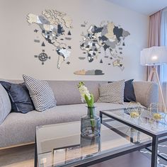 a living room filled with furniture and a large map on the wall above it's glass coffee table