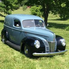 an old car is parked in the grass