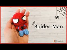 a hand holding a small crocheted spider man