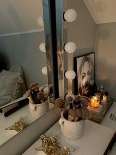 a bathroom vanity with a mirror and lights on the wall above it, along with other items