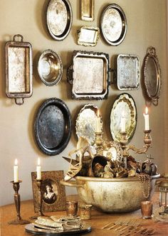 there are many plates on the wall with candles