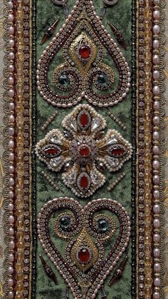 an intricately designed wall hanging with beads and pearls on it's sides,