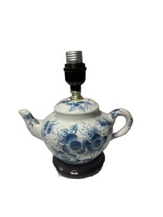 a blue and white tea pot with a black top