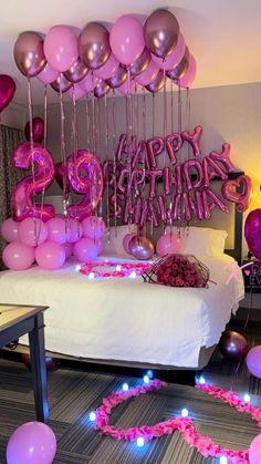 a room with balloons and streamers on the floor, some are pink in color