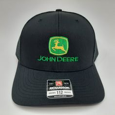 the john deere trucker hat is black with green embroidery on the front and side