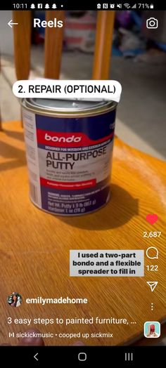 a can of paint sitting on top of a wooden table next to a phone screen