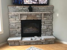 a television mounted on top of a stone fireplace