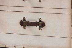 a close up of a drawer with two handles and brass hardware on the bottom part of it