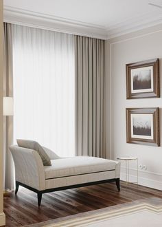 a white chaise lounge chair sitting in front of a window with drapes on it