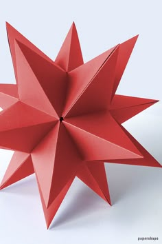 a red origami star on a white background