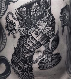 the back of a man's chest with an intricate tattoo design on his stomach