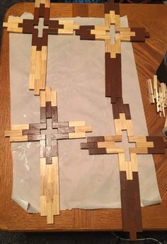 a wooden table topped with lots of cut up pieces of wood on top of paper