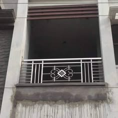 an iron balcony railing on the side of a gray building with white balconies