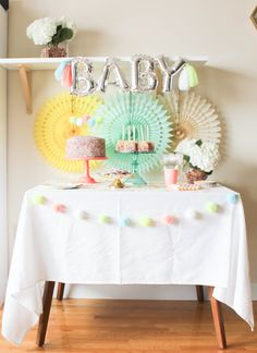 a baby shower table with cake and decorations