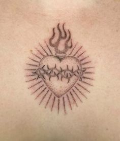 a tattoo on the back of a woman's chest with flames coming out of it