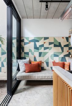 a living room with colorful tiles on the wall