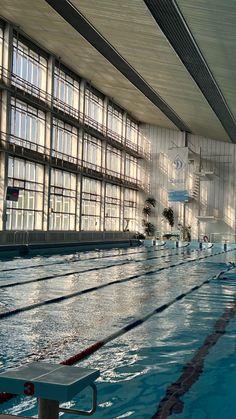 an empty swimming pool with no people in it and windows on the wall above them