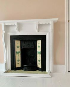 an empty fireplace in a room with pink walls