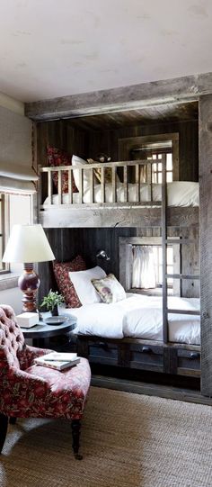 a bedroom with bunk beds and a chair in front of the bed is made out of wood