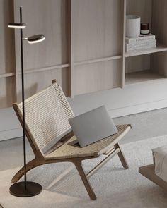 a laptop computer sitting on top of a wooden chair in front of a book shelf