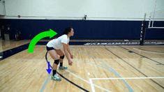 a woman in white shirt and black shorts playing volleyball on court with green arrow pointing to ball