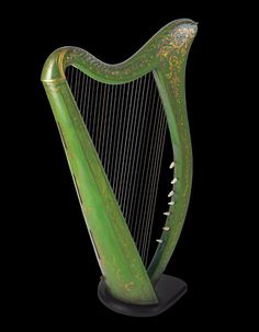 an ornate green harp with gold decoration on it's sides and the strings down