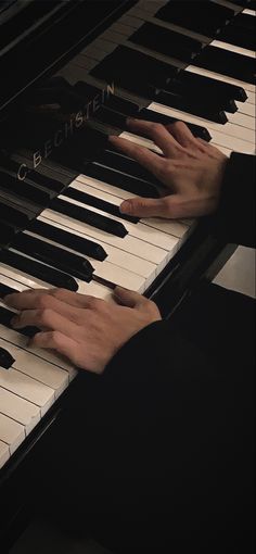 two hands are playing the piano together