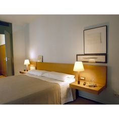 a hotel room with a bed, night stand and two lamps on the nightstands