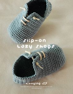 two crocheted baby shoes sitting on top of a bed