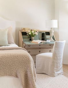 a bedroom with a bed, desk and chair next to a dresser in the corner