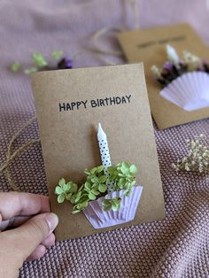 someone is holding a birthday card with flowers in it