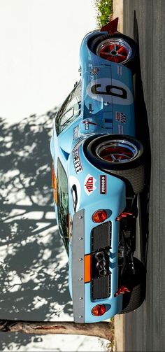 a blue race car parked next to a white wall