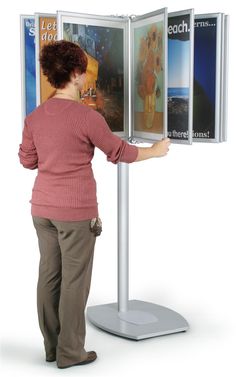 a woman standing in front of a poster display