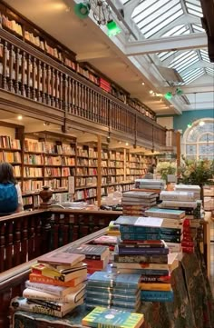 a library filled with lots of books and people sitting at the tables in front of them