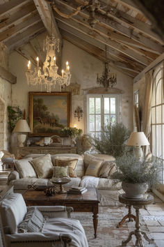 a living room filled with furniture and a chandelier hanging from the rafters