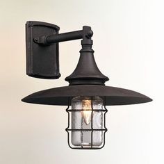 an outdoor wall light with a caged glass bulb on the front and back of it