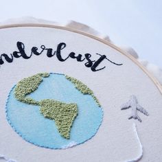 an embroidered earth with the word wander on it