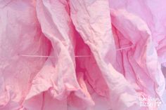 pink tissue paper is hanging on a clothes line