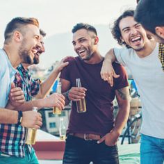 group of men laughing and drinking beer together