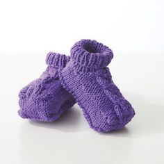 pair of purple knitted baby booties on white surface