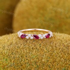 a diamond and ruby ring sitting on top of grass